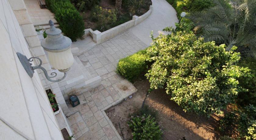 a large stone building with a garden area, Auberg-Inn Guesthouse in Jericho