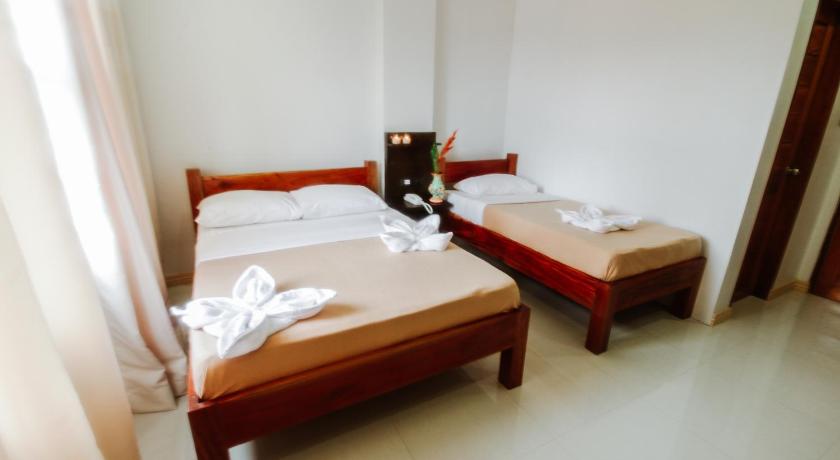 a hotel room with two beds and two lamps, Hotel Lapira in Ilocos Sur
