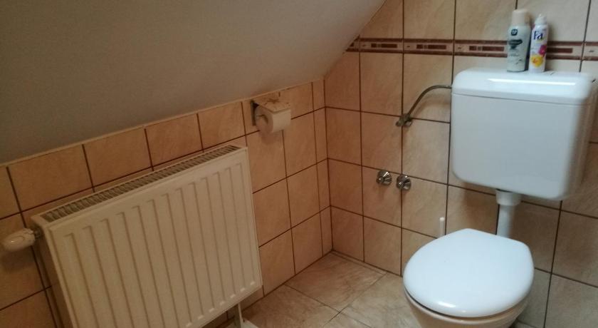 a white toilet sitting next to a white sink, Livia Apartman in Buk