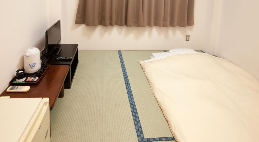 a room with a bed, desk and a television, Business Hotel Isesaki Heisei Inn in Isesaki