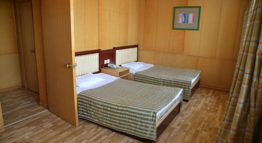 a bedroom with a bed and a dresser, Zaluuchuud Hotel Ulaanbaatar in Ulaanbaatar