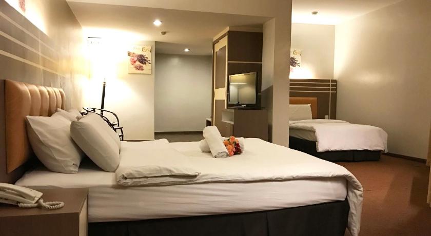 a hotel room with a bed and a desk, The Landmark Hotel in Batu Pahat