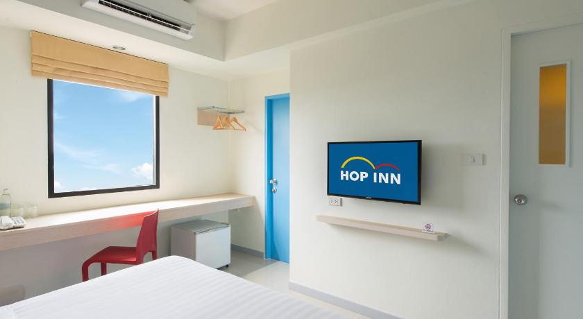 a hotel room with a television on the wall, Hop Inn Chumphon (SHA Extra Plus) in Chumphon
