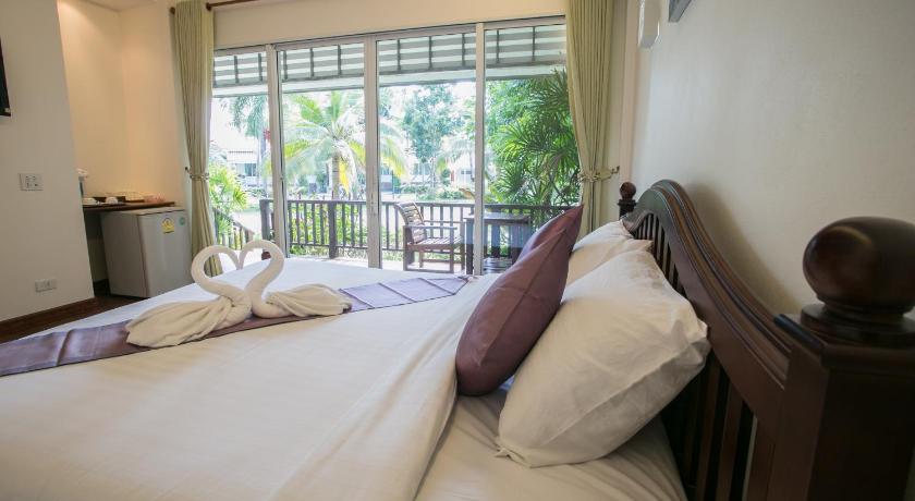 a bed with pillows and pillows in a hotel room, Nisasiri Boutique Resort in Chanthaburi