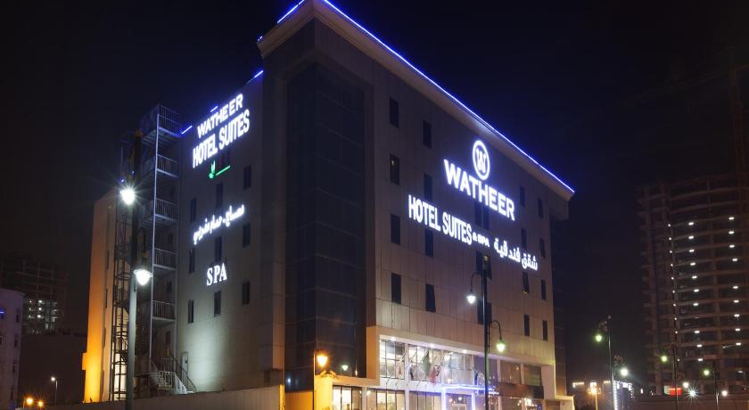 a large building with a neon sign on the side of it, Hyata Watheer Hotel & Suites in Dammam