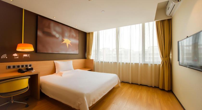 a hotel room with a bed and a television, IU Hotel Zhengzhou Lvcheng Square Metro Station in Zhengzhou