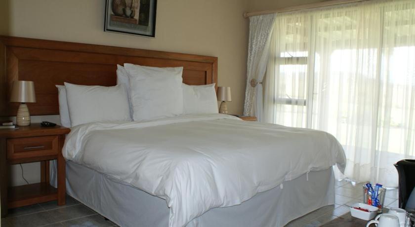 a white bed with a white comforter and pillows, Mountain View Guest House in Dundee