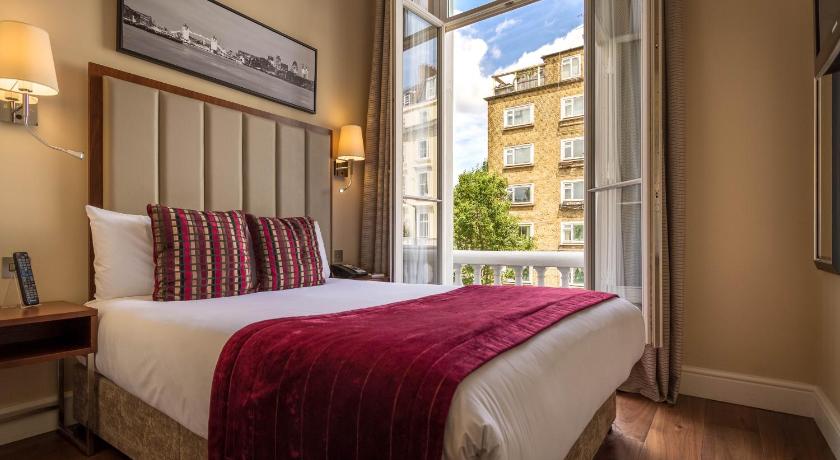 a bedroom with a large bed and a large window, The Belgrave Hotel in London