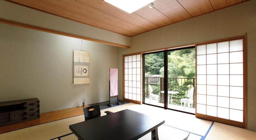a living room filled with furniture and a large window, Hakone Shiunso in Hakone