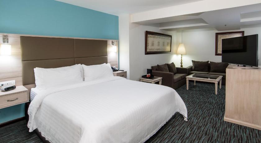 a hotel room with two beds and a television, Holiday Inn & Suites Mexico Zona Reforma in Mexico City