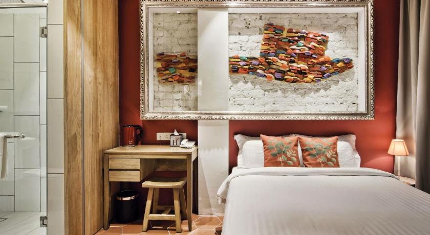 a bedroom with a bed and a painting on the wall, Timez Hotel Malacca in Malacca