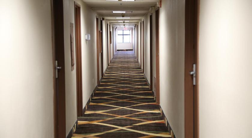 a hallway with a door leading into a room, Baymont by Wyndham Plano in Dallas (TX)