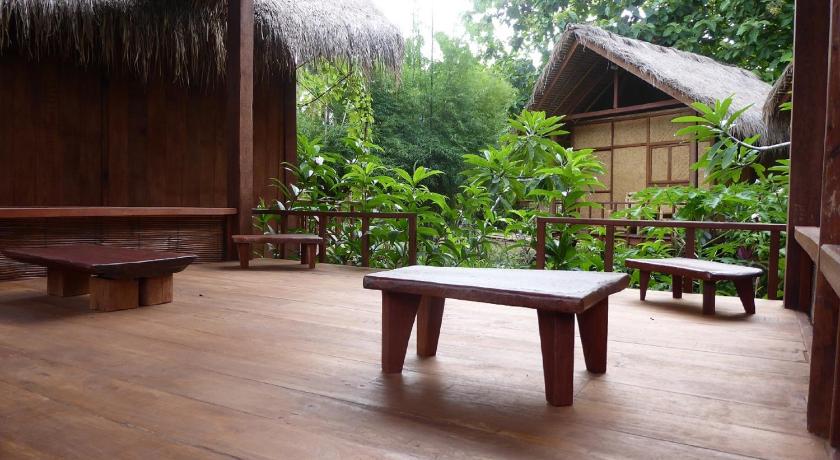 a wooden bench sitting in front of a patio, Shibui Garden Bungalows and Restaurant in Lombok