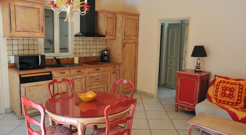 a kitchen with a table, chairs and a refrigerator, Villa Valflor chambres d'hotes et appartements in Marseille