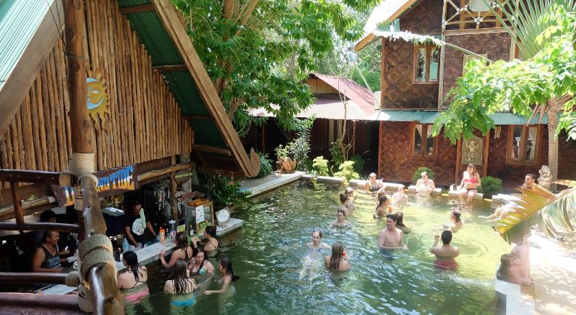 people are swimming in a pool of water, Tropical Garden Bungalow in Ko Phi Phi