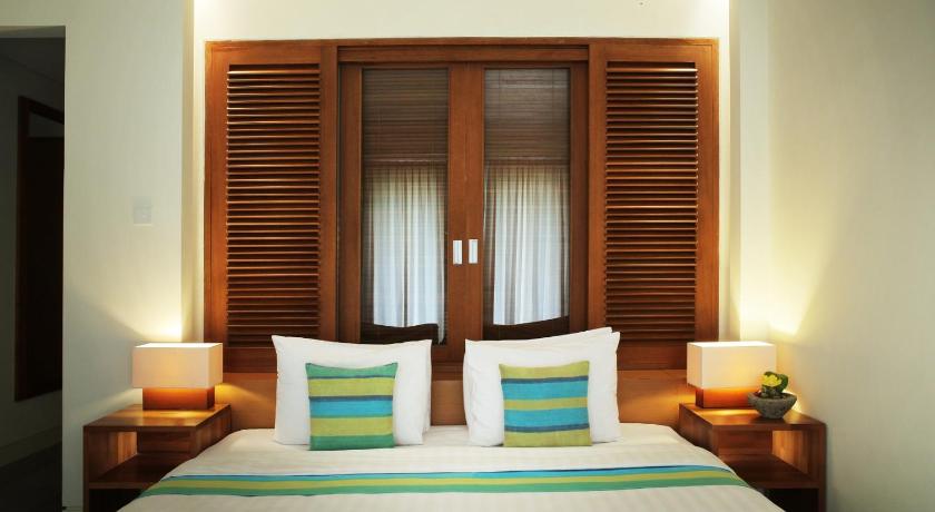 a hotel room with a bed and two lamps, Billiton Hotel in Belitung