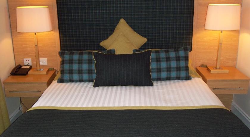 a bed with a white comforter and pillows, Northern Hotel in Brechin