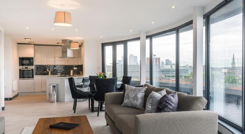 a living room filled with furniture and a window, Aldgate Apartments in London
