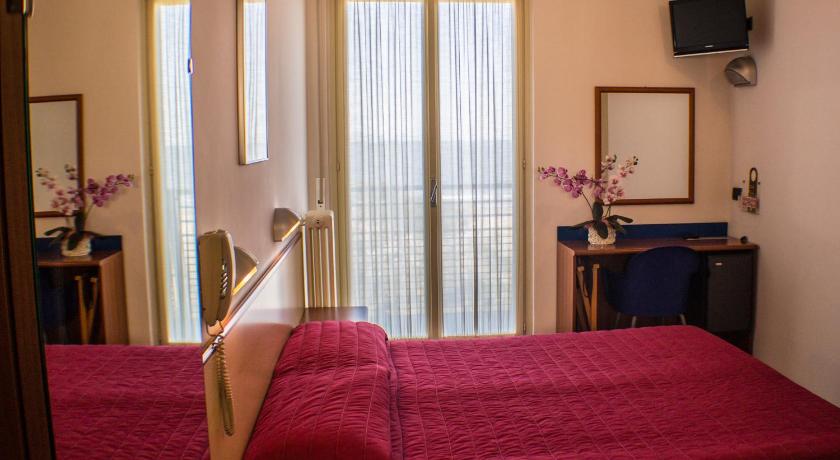 a hotel room with a bed and a desk, Hotel Brasilia in Ravenna