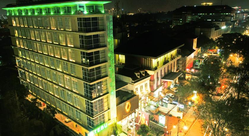 a city street at night with tall buildings, Tebu Hotel Bandung in Bandung