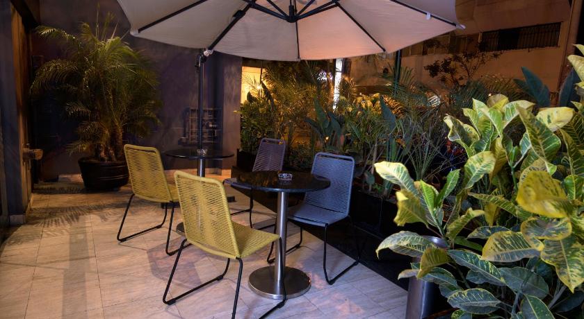 a patio area with chairs, tables, and umbrellas, Mariel Hotel Boutique in Lima