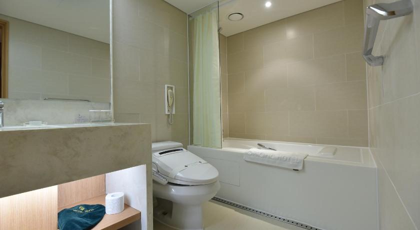 a white toilet sitting next to a bath tub in a bathroom, Pacific Hotel in Seoul