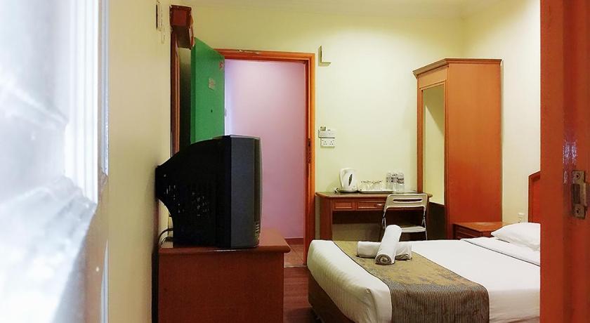 a hotel room with a bed and a television, SkyGlobal Hotel in Labuan