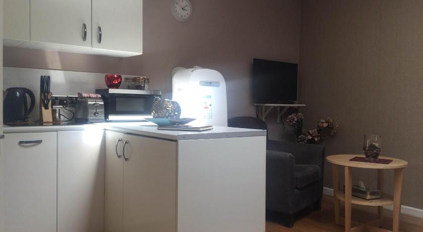 a kitchen with a stove, microwave, and refrigerator, Studio Apartments Camden Town in London