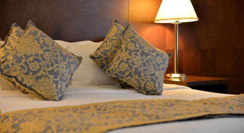 a bed with two pillows on top of it, Royal Inn Nozol Hotel in Medina