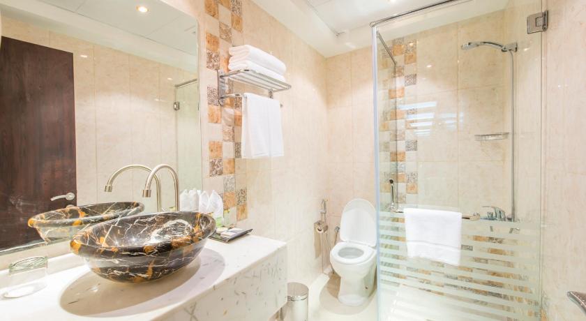 a bathroom with a sink, toilet and shower stall, Royal Tulip Hotel in Dubai