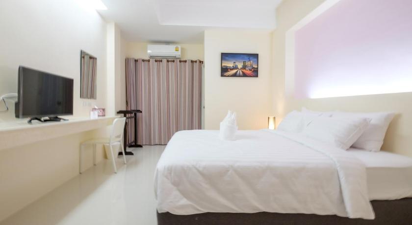 a hotel room with a bed and a television, Wisdom Hotel in Samut Songkhram