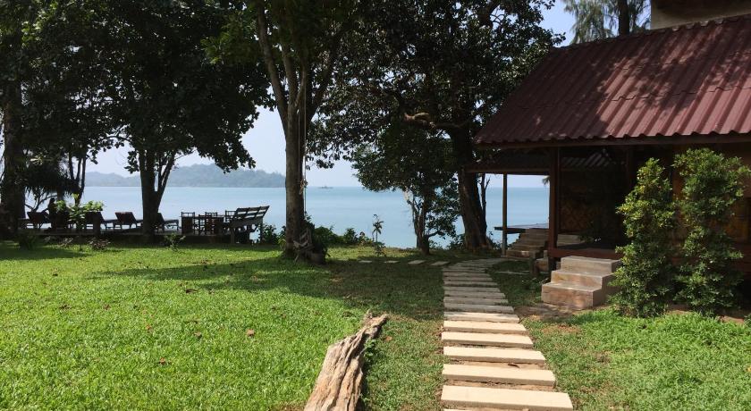 a wooden bench sitting on top of a lush green hillside, Starlight Beach Resort in Koh Phayam (Ranong)