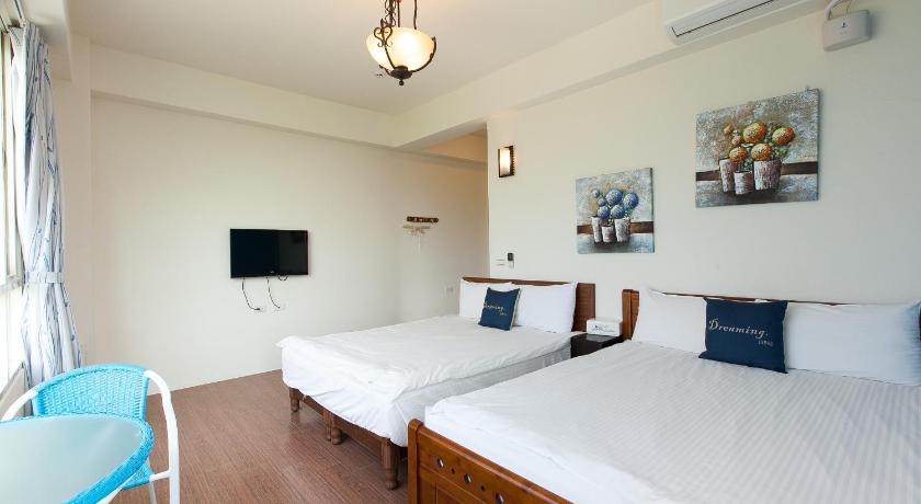 a hotel room with a bed and a television, Dongshan Township Free Garden Bed and Breakfast in Yilan