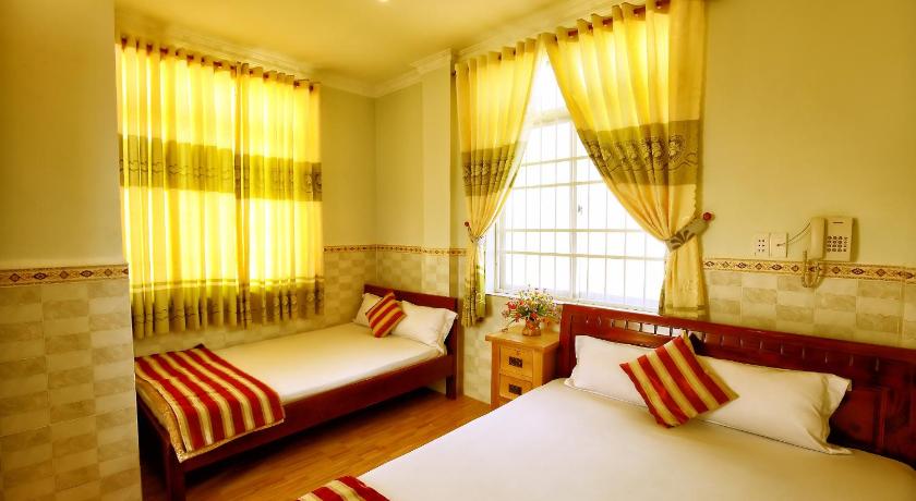 a hotel room with two beds and a large window, Hoang Linh Hotel in Vung Tau