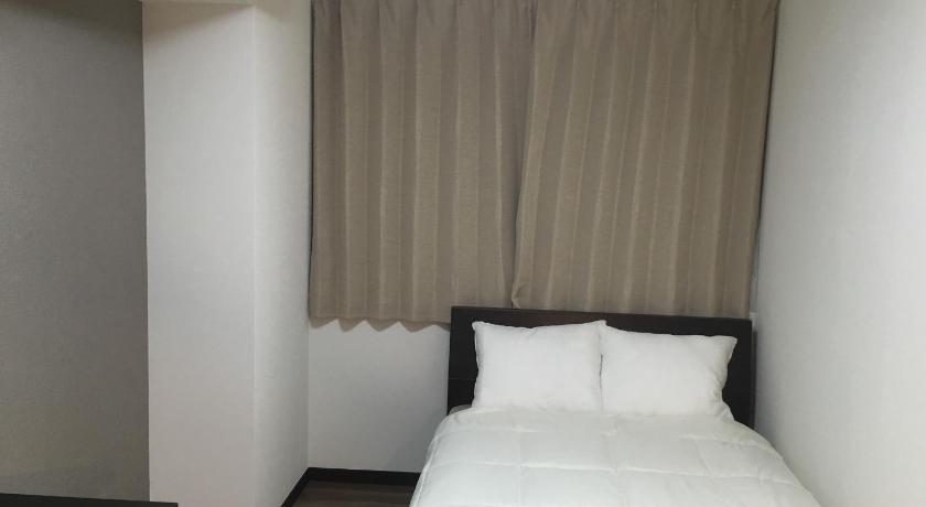 a white bed with a white comforter in a room, TIMES INN 2F in Tokyo