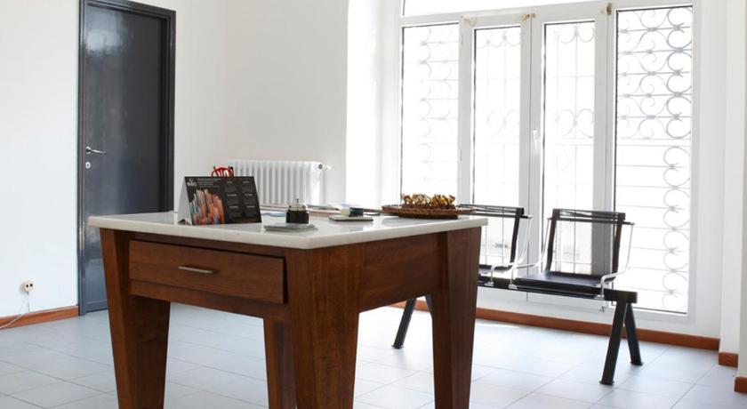 a living room with a table, chairs and a tv, Foresteria SoloSonno in Malgrate