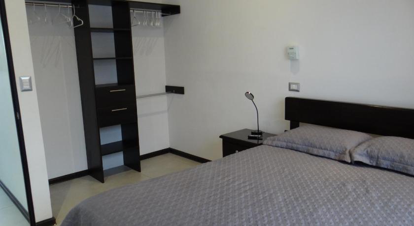 a bedroom with a bed and a dresser, Maria´s Apartments in Alajuela
