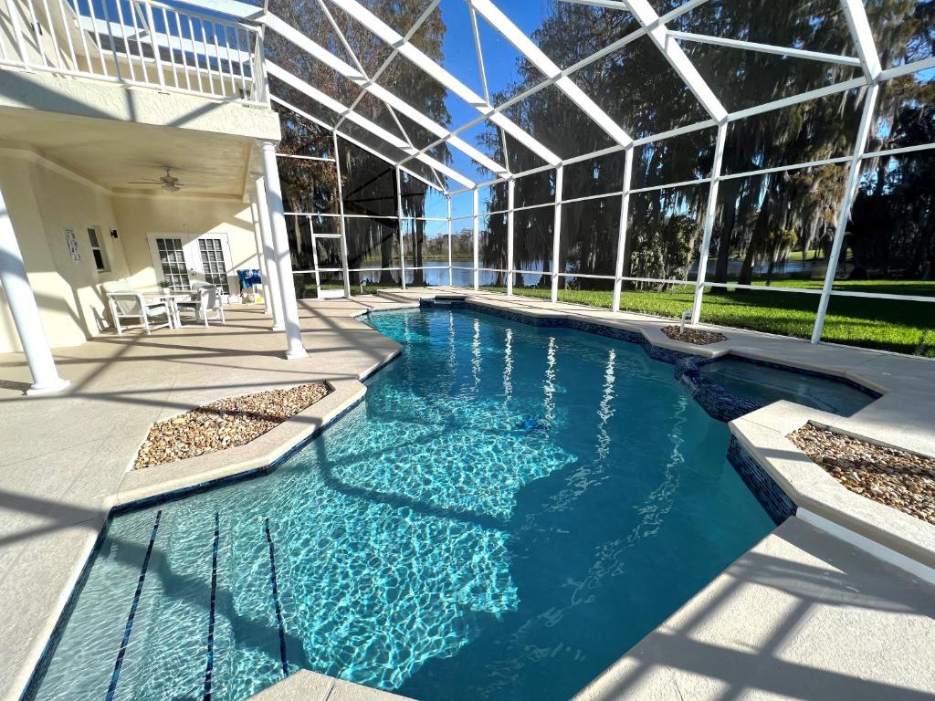 Mickeys Homestead - Stylish 4BR Lakefront Cottage with Huge South Facing Pool Hot Tub BBQ - 2 miles Disney! image