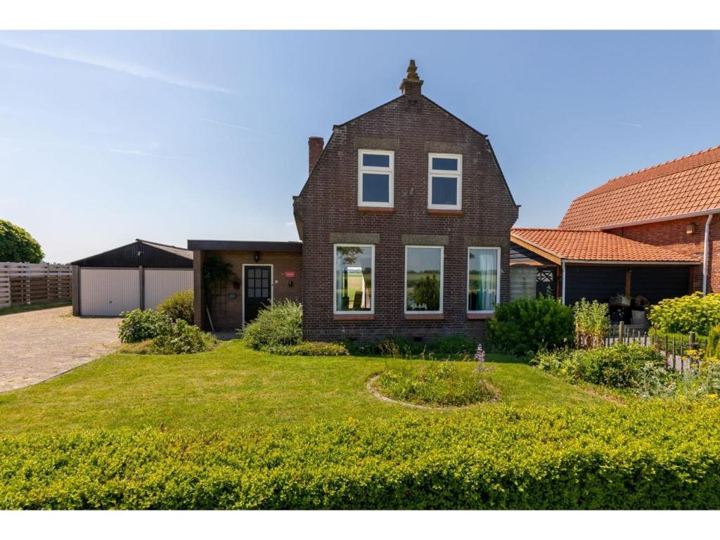 characteristic house in a rural location in the village of Zuidzande with garden