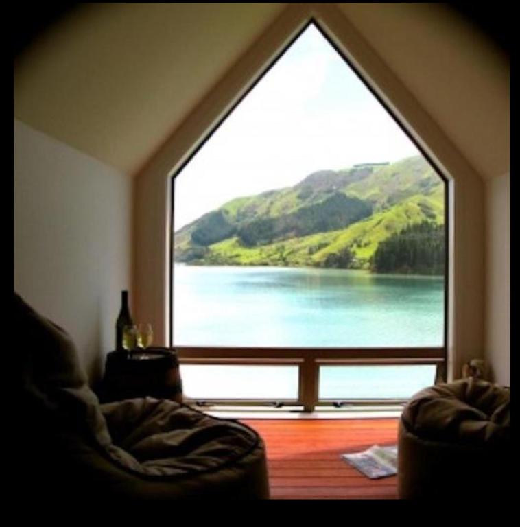 a window overlooking a body of water with a view of a lake, Cable Bay Nest in Nelson