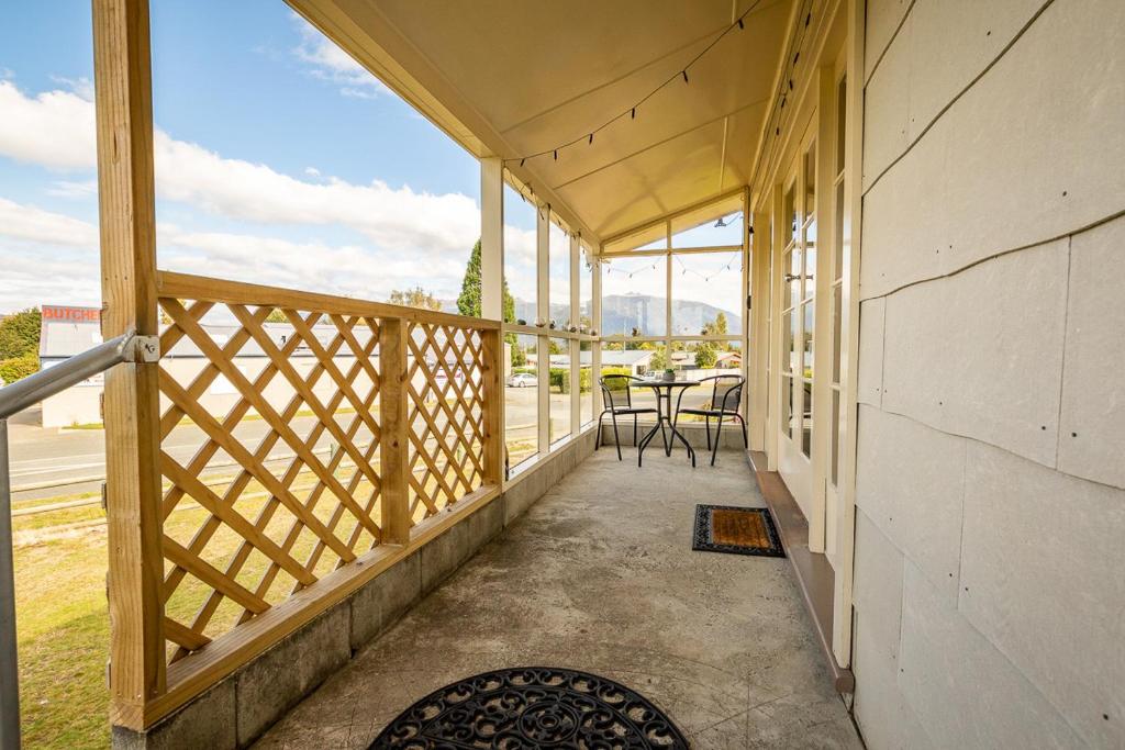 a patio area with a table, chairs, and a fence, Grand View - Te Anau Holiday Home in Te Anau