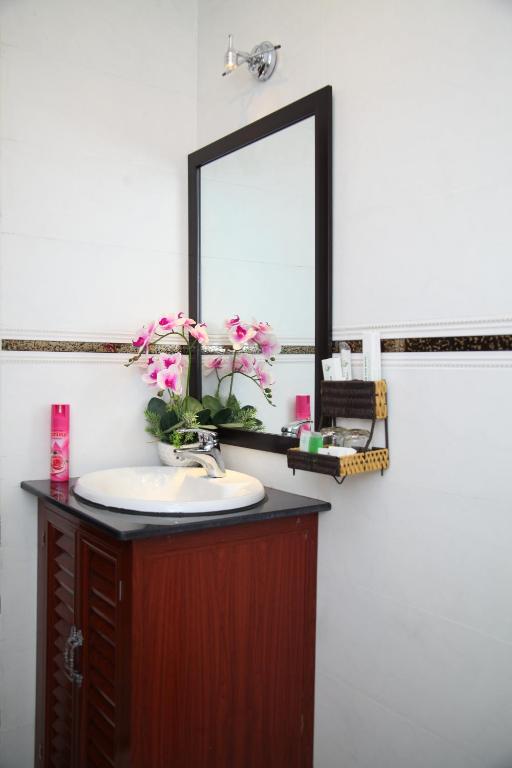a bathroom sink with a mirror and flowers in it, Minh Tam Hotel and Spa in Ho Chi Minh City