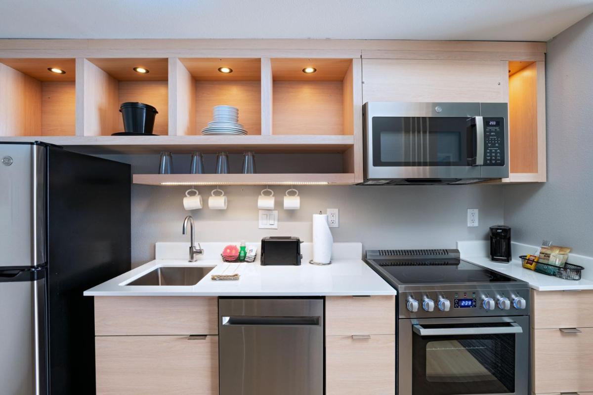 Suite kitchen with refrigerator, range, microwave, and dishwasher at TownePlace Suites by Marriott Stafford Sugar Land