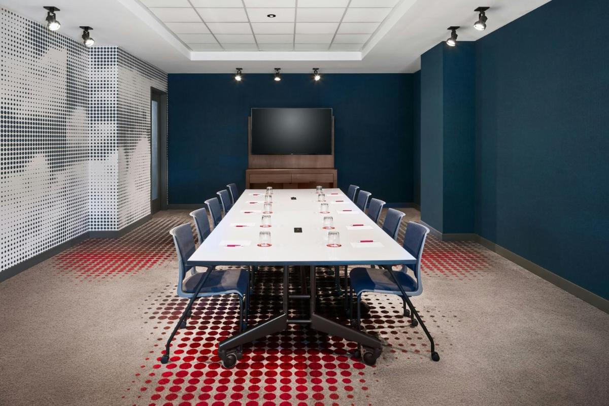 Meeting room with a conference table, chairs, and display at Aloft by Marriott San Francisco Airport