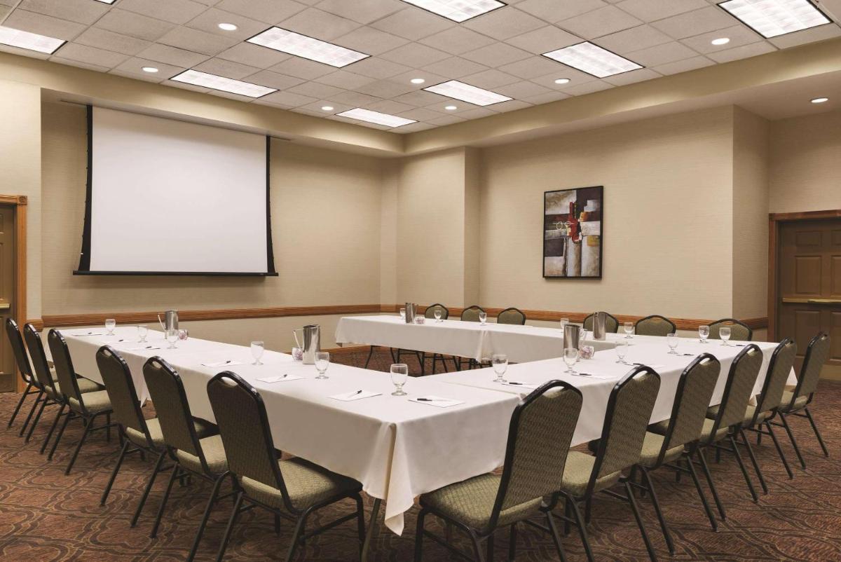 Conference room with tables, chairs, and a presentation screen at Country Inn & Suites in Mankato
