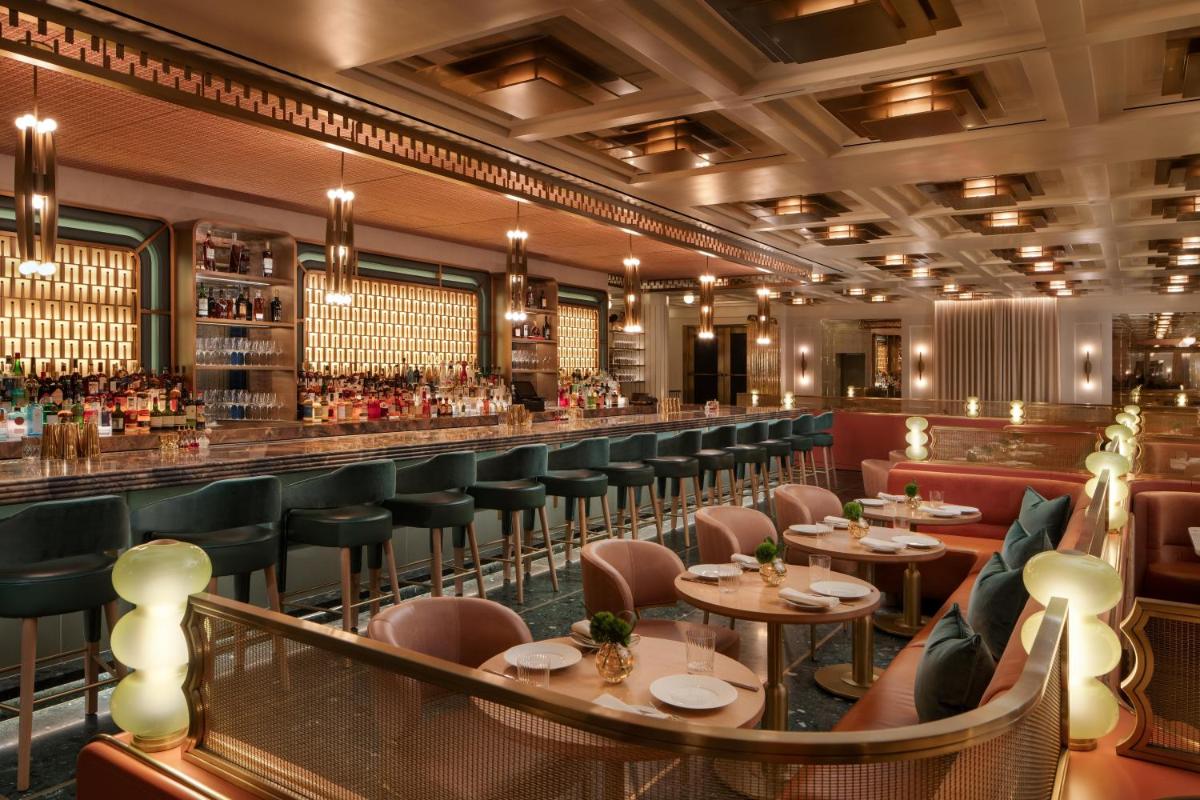 Restaurant and bar at Waldorf Astoria New York with booth seating and warm wood finishes