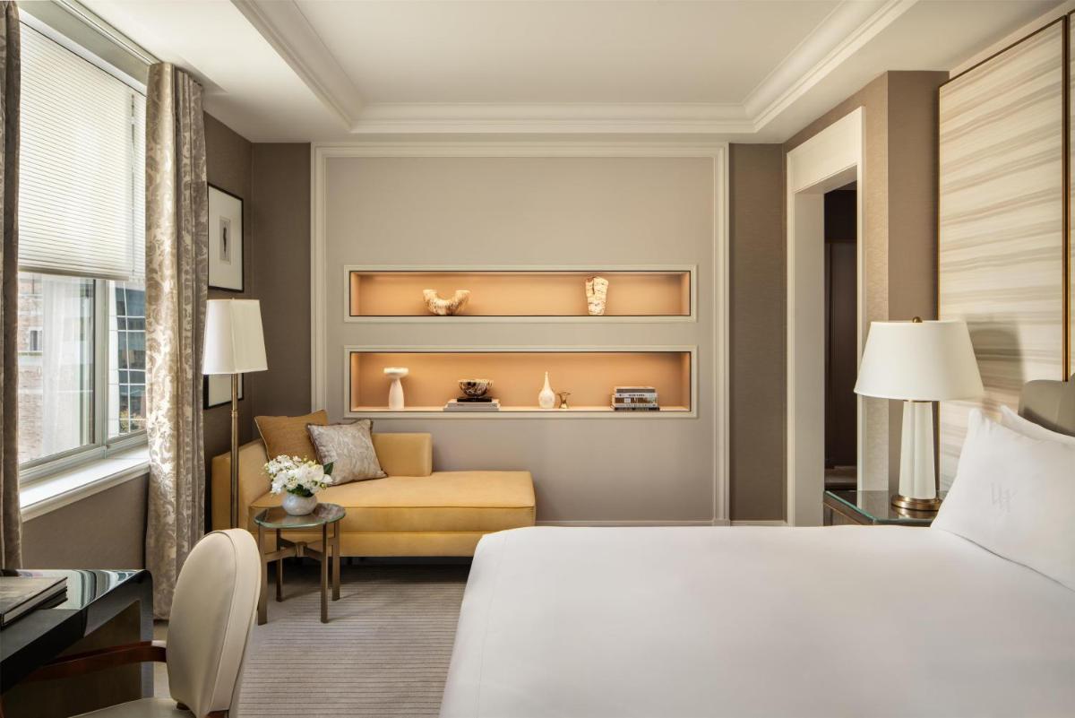 Waldorf Astoria New York guest room with a bed, seating, and tall windows