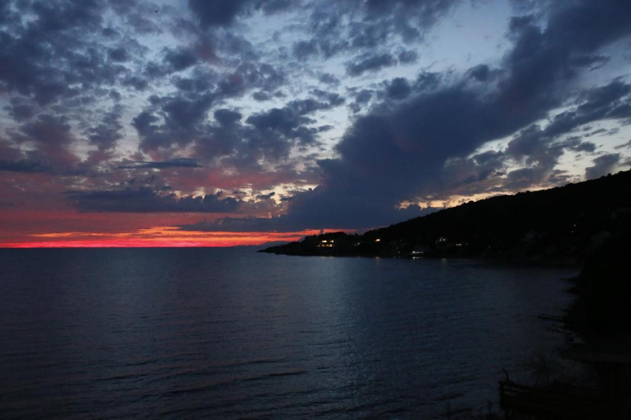Dark rocky coastline with lit houses sits at dog-friendly Casa Mila Apartments & Bungalows in Ulcinj.