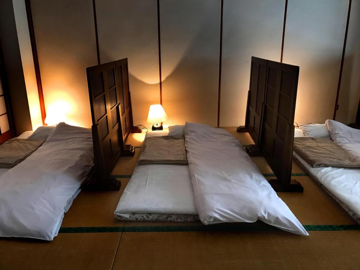 Cama individual tipo futón en habitación compartida para hombres de estilo japonés