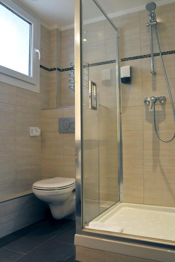 A white wall-mounted toilet sits at dog-friendly Hôtel Des Quatrans in Caen.